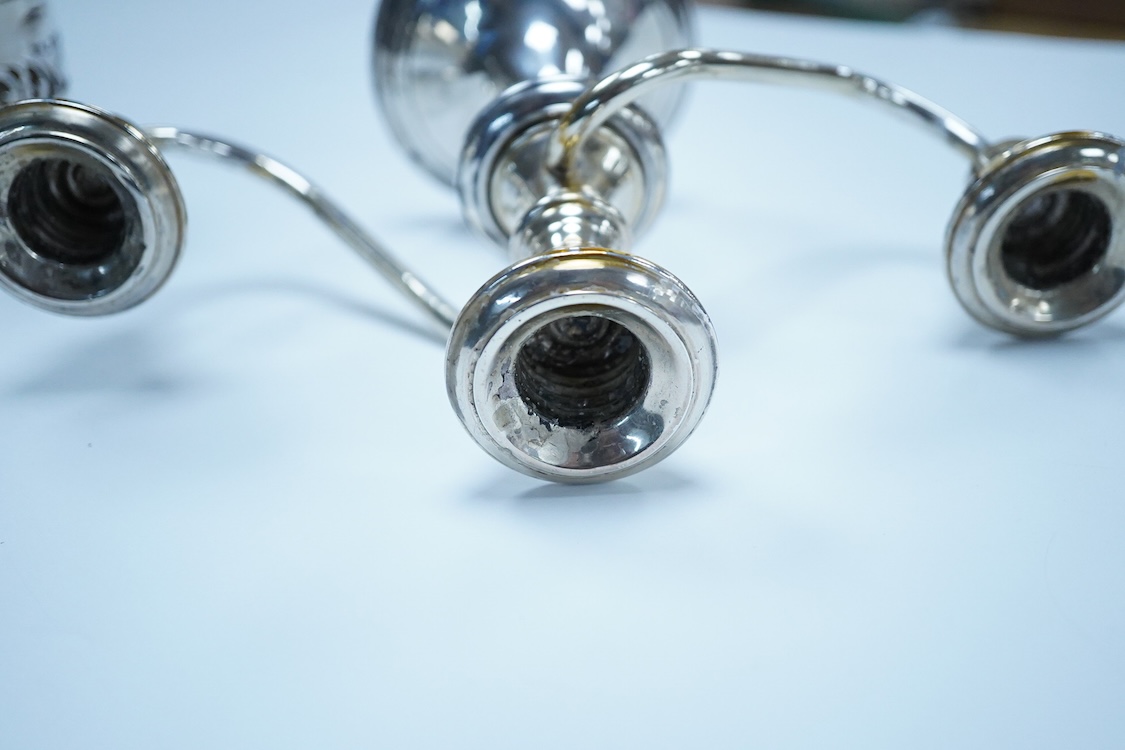 A North America sterling two branch, three branch candelabrum, by Frank M. Whiting & Co, height 15.4cm, weighted, together with a pierced 900 standard white metal bottle coaster, 5.4oz.